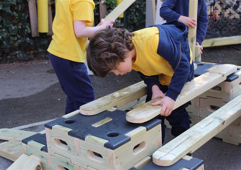 School girl balancing on wooden planks in the playground - Playbuilder